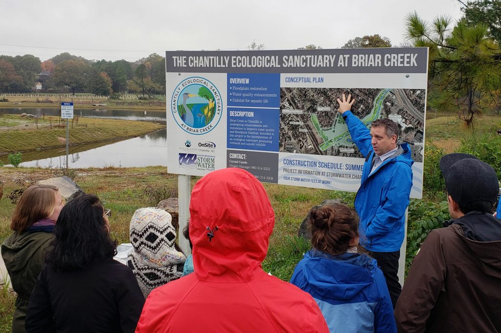 Mecklenburg County Storm Water Engineering & Flood Mitigation Program Manager Tim Trautman explains the county’s buyout program to students in CRC Director Gavin Smith’s “Natural Hazards and Climate Change” course during a trip to Charlotte on Nov. 9, 2018. Trautman explained the process by which half of an apartment complex east of downtown Charlotte was bought out and converted to a public park in the floodplain, increasing the value of some nearby homes.