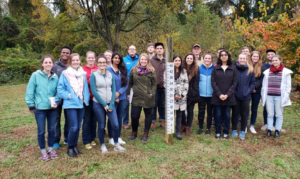 Dr. Smith’s class poses at a flood gauge during the final stop of their tour of buyout and retrofit projects in Charlotte.